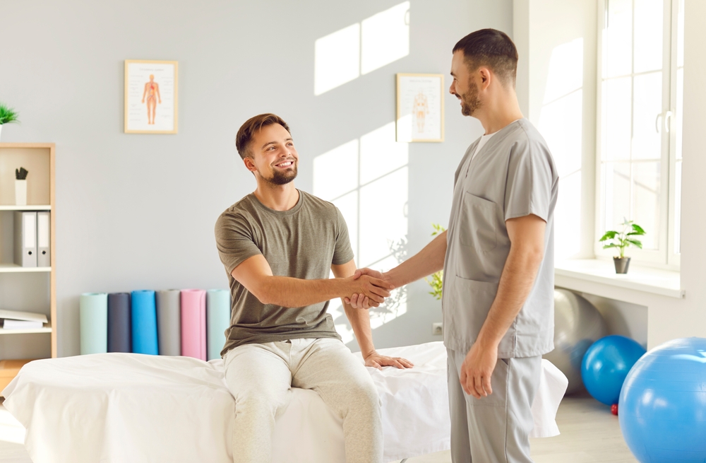 Happy,Patient,And,Rehabilitation,Therapy,Professional,Trainer,Nurse,Hand,Shake,